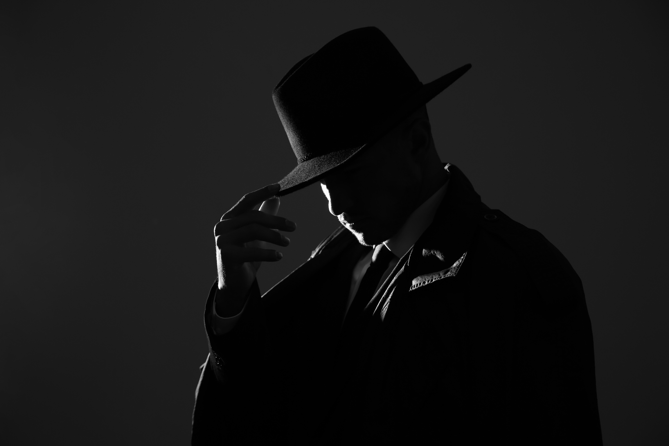 Old Fashioned Detective in Hat on Dark Background, Black and Whi
